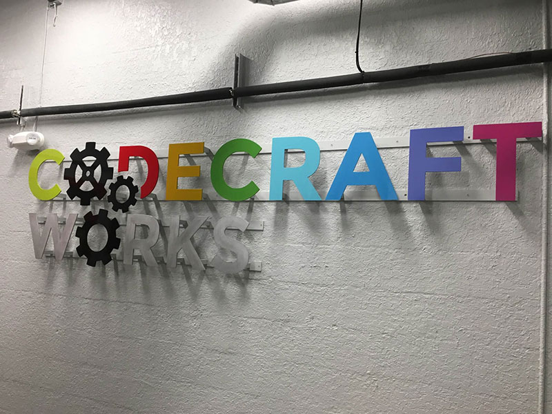 Physical Codecraft Works logo hanging on a wall