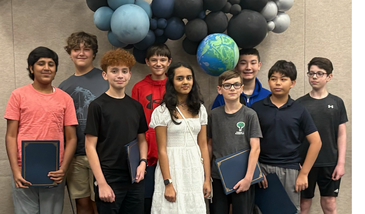 A group of nine students smile for a photo.